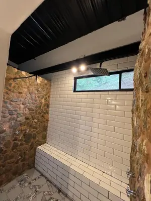 a bathroom with white brick walls and a window at Cabañas DALI la catedral in Envigado