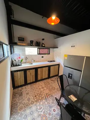 a kitchen with a sink and a table in it at Cabañas DALI la catedral in Envigado
