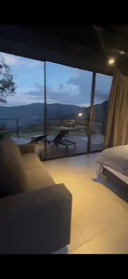 a bedroom with a bed and a large glass window at Cabañas DALI la catedral in Envigado