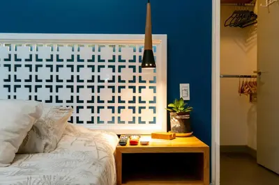 a bedroom with a blue wall and a bed and a table at Homely Penthouse in Provenza in Medellín