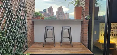 two bar stools on a balcony with a city skyline at Homely Penthouse in Provenza in Medellín