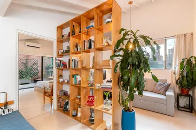 a living room with a large wooden book shelf at Homely Penthouse in Provenza in Medellín