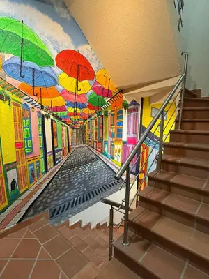 a mural of a hallway with umbrellas on the wall at Nuevo apartamento en plaza principal de Guatape in Guatapé