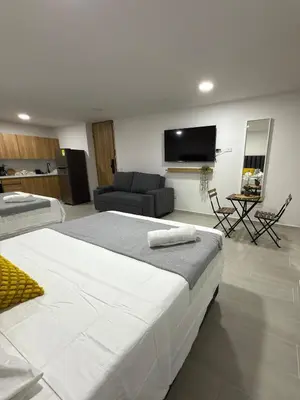 a bedroom with a large bed and a living room at Nuevo apartamento en plaza principal de Guatape in Guatapé