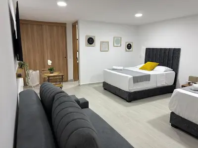 a living room with two beds and a couch at Nuevo apartamento en plaza principal de Guatape in Guatapé