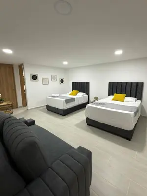 a living room with two beds and a couch at Nuevo apartamento en plaza principal de Guatape in Guatapé