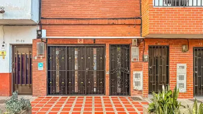 a brick building with black doors on it at Laureles Coliving House Medellín in Medellín