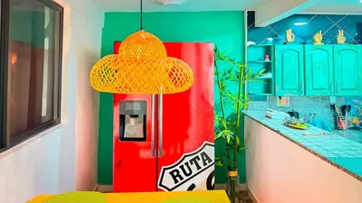 a colorful kitchen with a red and green refrigerator at Laureles Coliving House Medellín in Medellín
