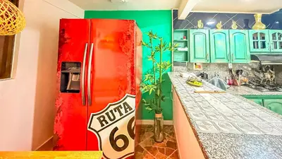 a red refrigerator in a kitchen with green cabinets at Laureles Coliving House Medellín in Medellín