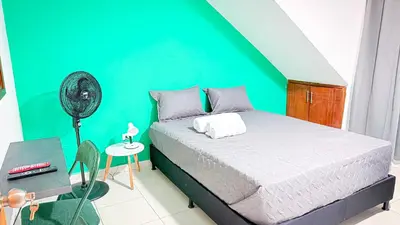a bedroom with a bed and a green wall at Laureles Coliving House Medellín in Medellín