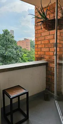 a stool sitting on a balcony with a brick wall at Exclusive penthouse in Provenza in Medellín