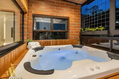 a jacuzzi tub in a room with a brick wall at Tivoli 202 - Escapada Premium con Jacuzzi Privado in Medellín