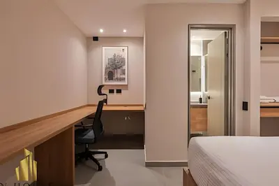 a bedroom with a bed and a desk with a chair at Tivoli 202 - Escapada Premium con Jacuzzi Privado in Medellín