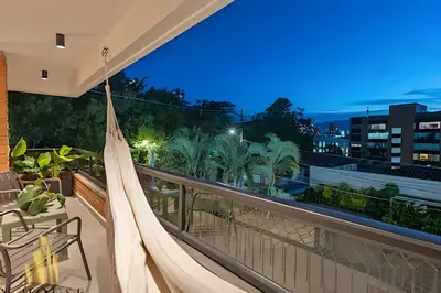 a hammock on the balcony of a house at night at Tivoli 202 - Escapada Premium con Jacuzzi Privado in Medellín