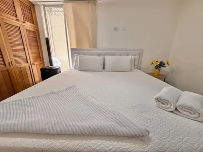 a bedroom with a white bed with towels on it at Medellín Poblado Gem Steps to Cafés & Nightlife in Medellín