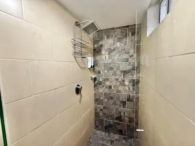 a bathroom with a shower with a stone wall at Medellín Poblado Gem Steps to Cafés & Nightlife in Medellín