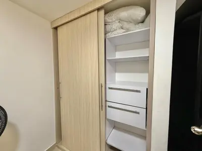 a closet with white shelves in a bathroom at Medellín Poblado Gem Steps to Cafés & Nightlife in Medellín