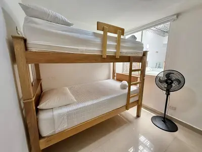 two bunk beds in a room with a fan at Medellín Poblado Gem Steps to Cafés & Nightlife in Medellín