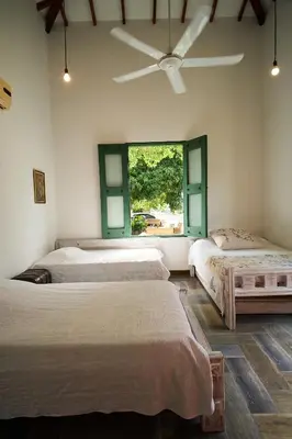 a bedroom with two beds and a window at Cauca Viejo parque Aliciadorada in Jericó