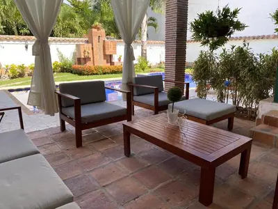 a patio with chairs and a table and a pool at Cauca Viejo parque Aliciadorada in Jericó