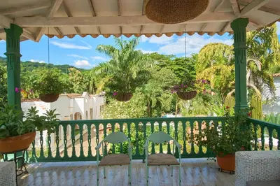 a porch with chairs and a fence and trees at Cauca Viejo parque Aliciadorada in Jericó