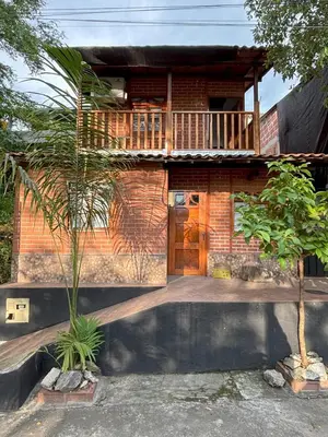 a brick house with a balcony on top of it at Casa refugio Natural in Puerto Triunfo