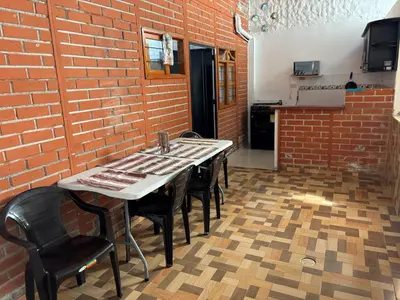 a kitchen with a table and chairs and a brick wall at Casa refugio Natural in Puerto Triunfo