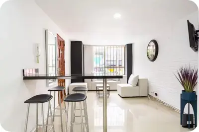 a kitchen and living room with a bar and stools at Group Stay in Poblado - Walk Everywhere - King Bed in Medellín