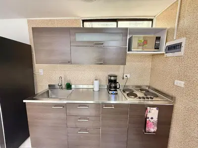 a small kitchen with a sink and a stove at Medellin Poblado Gem Walk to Provenza and Lleras in Medellín