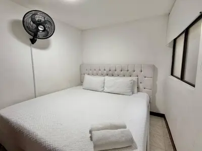 a bedroom with a white bed and a fan at Medellin Poblado Gem Walk to Provenza and Lleras in Medellín