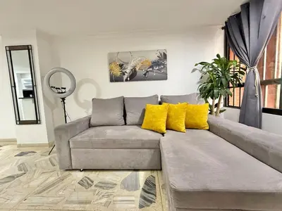 a living room with a gray couch and yellow pillows at Poblado Gem Walk to Provenza and Steps to Cafes in Medellín
