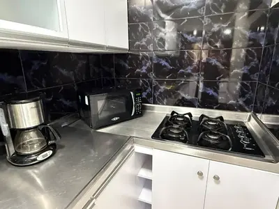 a kitchen with a stove top oven in a kitchen at Poblado Gem Walk to Provenza and Steps to Cafes in Medellín