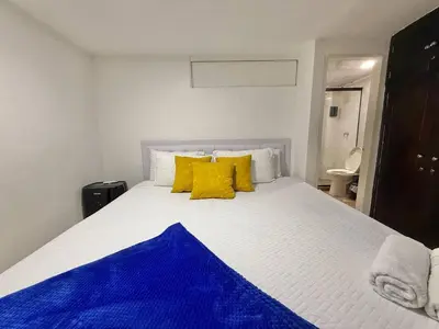 a bedroom with a large bed with yellow pillows at Poblado Gem Walk to Provenza and Steps to Cafes in Medellín