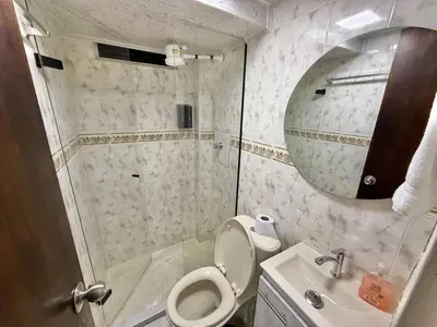a bathroom with a toilet and a sink and a mirror at Poblado Gem Walk to Provenza and Steps to Cafes in Medellín