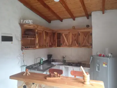 a kitchen with wooden cabinets and a sink and a refrigerator at Cabaña campestre in Medellín