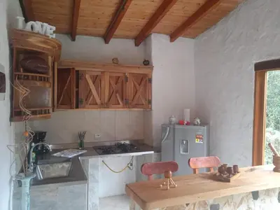 a kitchen with a wooden table and a refrigerator at Cabaña campestre in Medellín