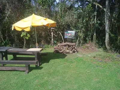 a picnic table with a yellow umbrella in the grass at Cabaña campestre in Medellín