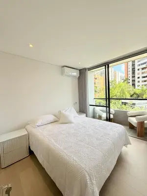 a bedroom with a white bed and a large window at Poblado de lujo in Medellín