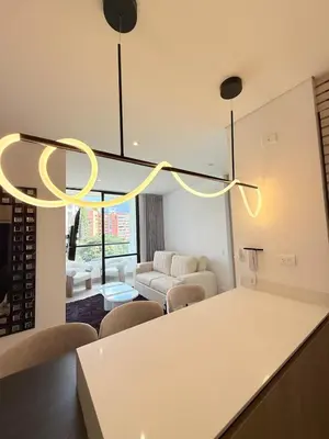 a kitchen and living room with a chandelier at Poblado de lujo in Medellín