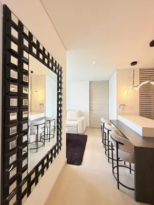 a kitchen and living room with a bar and stools at Poblado de lujo in Medellín