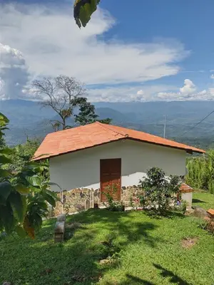 a small house with an orange roof on a hill at Country cabin with panoramic view among clouds - cabaña refugio entre nubes in Támesis