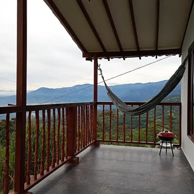 a hammock on a balcony with mountains in the background at Country cabin with panoramic view among clouds - cabaña refugio entre nubes in Támesis