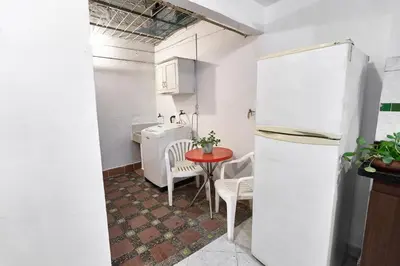 a small kitchen with a table and a refrigerator at Casa grande cerca al Poblado in Medellín