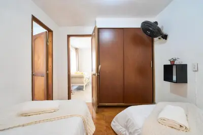 a bedroom with two beds and a wooden cabinet at Casa grande cerca al Poblado in Medellín
