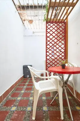 a red table and two white chairs in a room at Casa grande cerca al Poblado in Medellín
