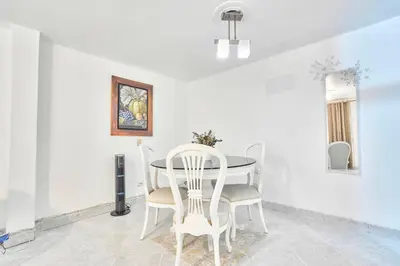 a white dining room with a table and chairs at Casa grande cerca al Poblado in Medellín