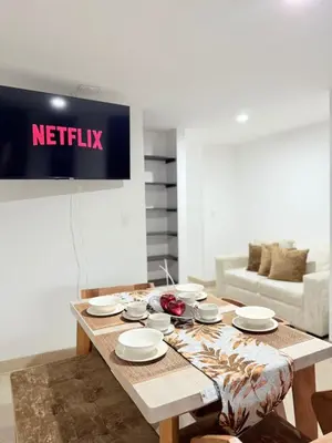 a living room with a wooden table with plates on it at APARTAMENTO EN LAURELES, Ambiente familiar in Medellín