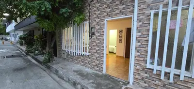 a brick building with a white door on a street at Alojamiento Sol Naciente in Puerto Triunfo