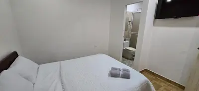 a bedroom with a bed with two towels on it at Alojamiento Sol Naciente in Puerto Triunfo