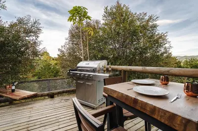 a grill sitting on a table on a deck with a tableablish at Retreat Villas Llanogrande By CHX in Rionegro